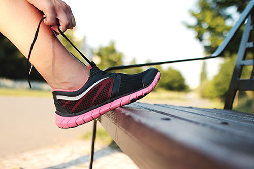 Image of girl tying a running shoe for Girls on the Run Program